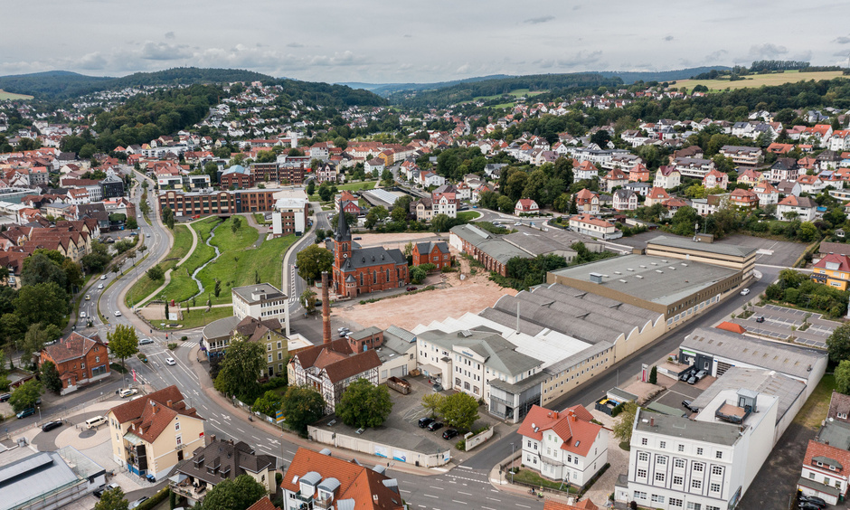 Luftaufnahme des Wever-Areals in Bad Hersfeld, in der Mitte die Lullus-Kirche, drumherum Häuser, Gewerbe und ein Park