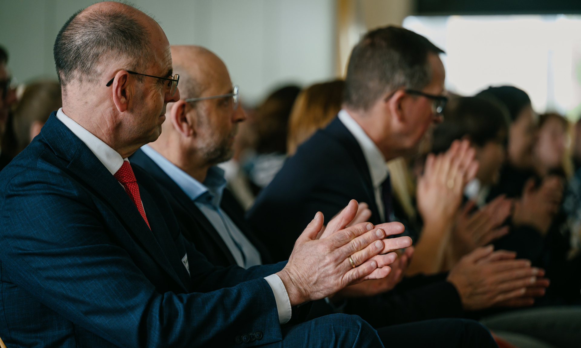 Mehrere schick gekleidete Menschen klatschen Beifall