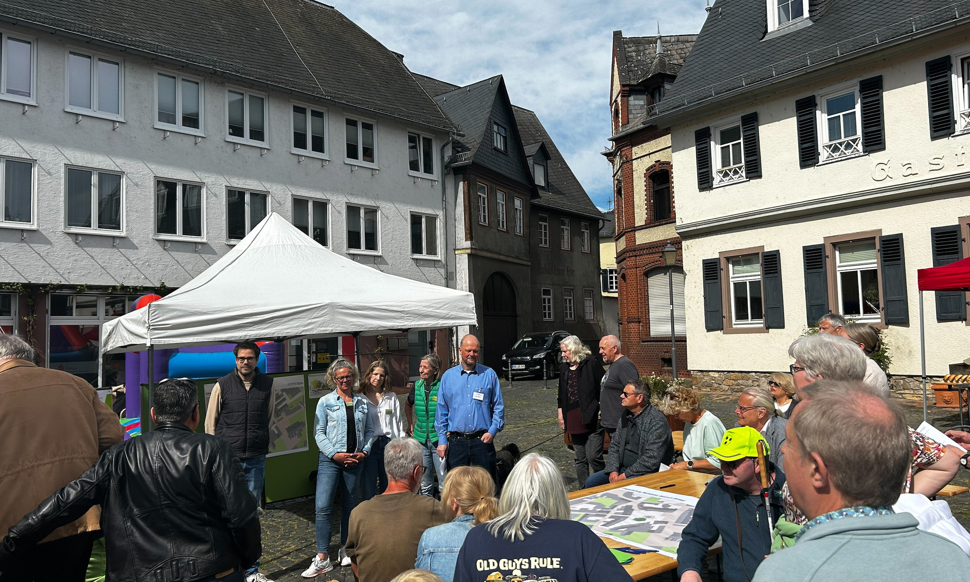 Gruppe von Menschen auf dem Marktplatz von Oestrich in der Stadt Oestrich-Winkel im Rheingau tauschen sich aus. 
