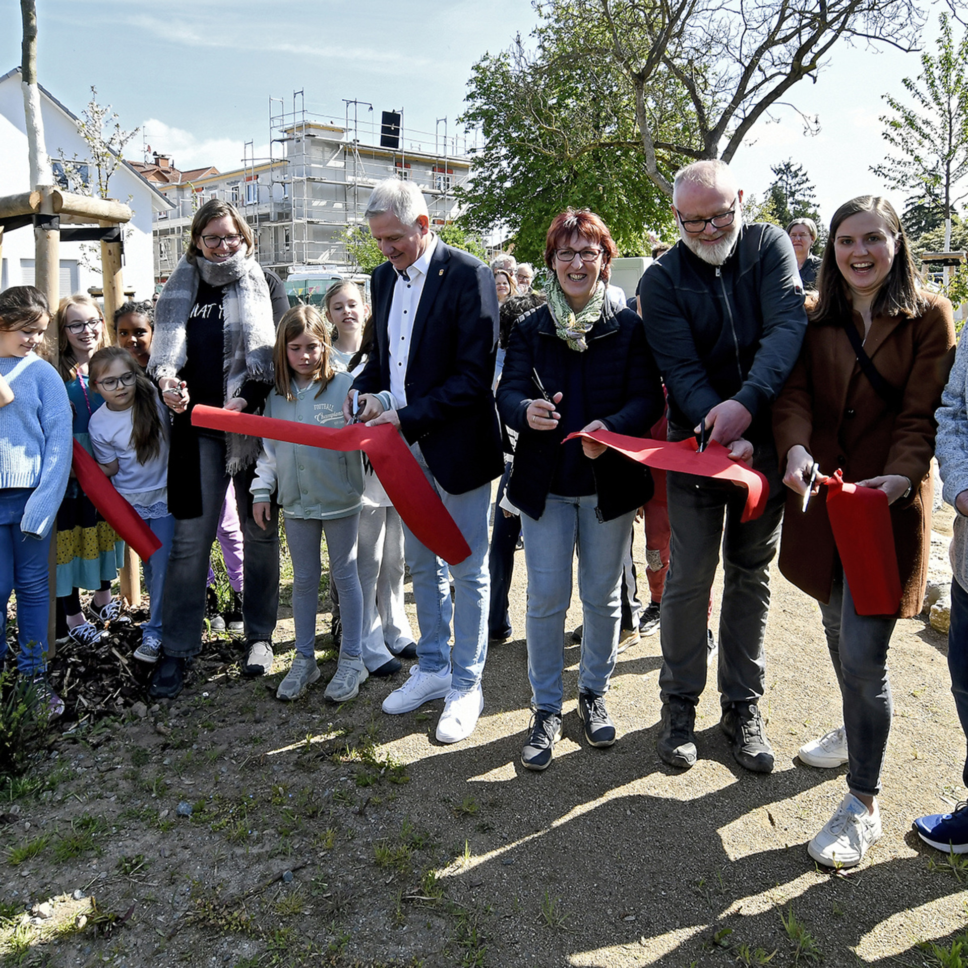 Kinder und Erwachsene durchschneiden das rote Band zur Einweihung des grün-blauen Klassenzimmers an der Weschnitz in Einhausen 
