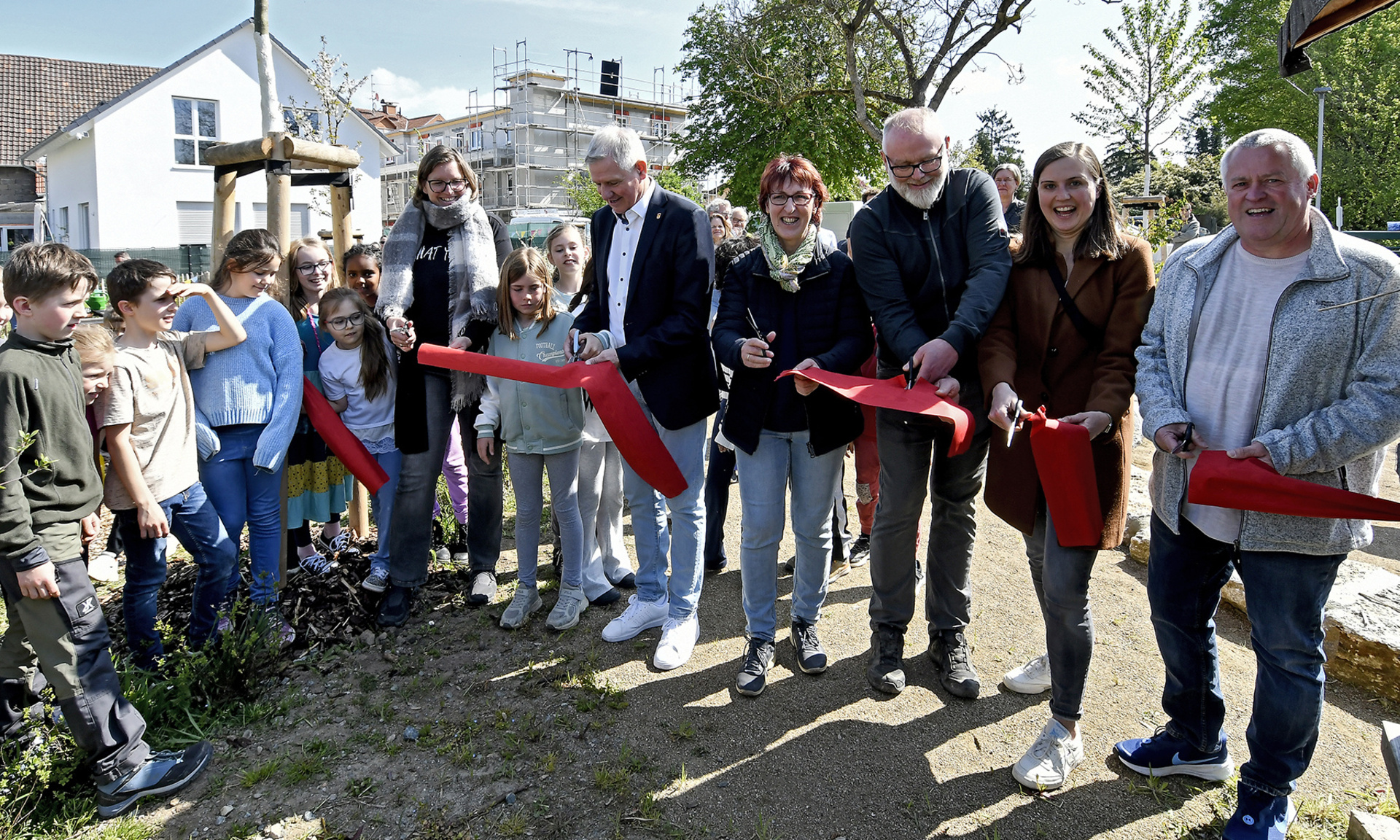 Kinder und Erwachsene durchschneiden das rote Band zur Einweihung des grün-blauen Klassenzimmers an der Weschnitz in Einhausen 