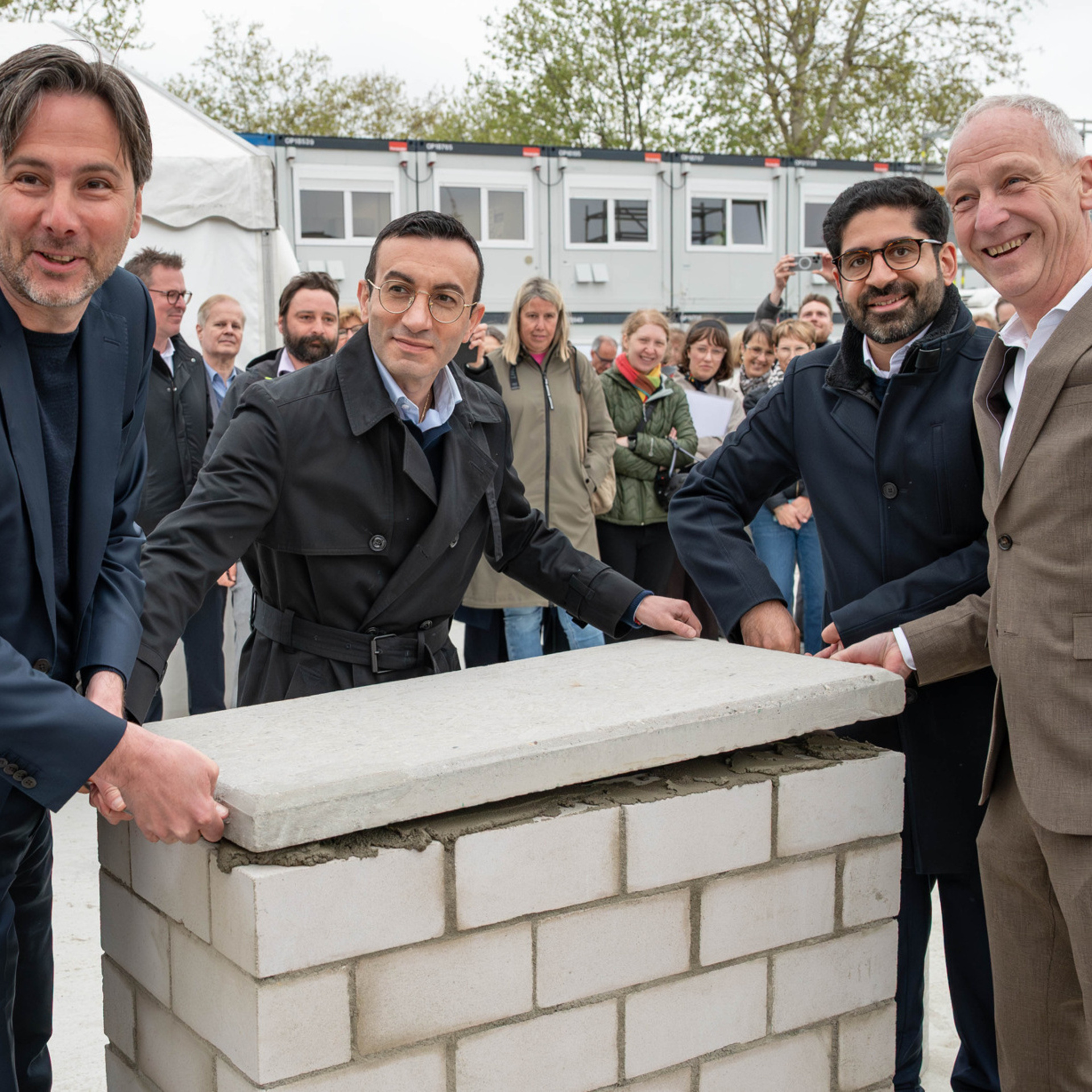 Die vier Personen steht um die Zeitkapsel herum und verschließen gerade den Deckel.