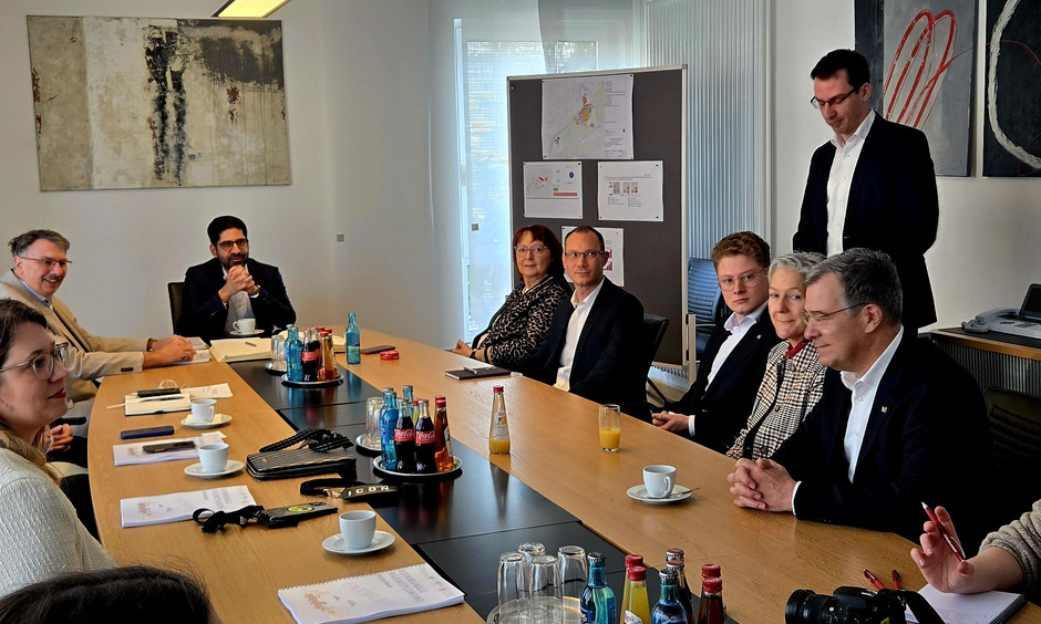 Der Minister sitzt an einem Konferenztisch mit den Stadtentwicklern.