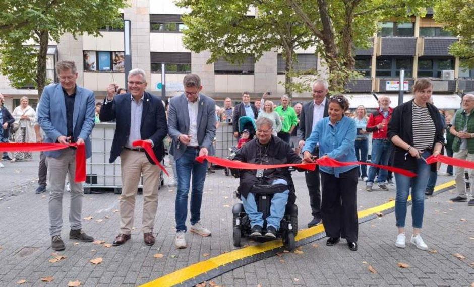 Mehrere Menschen durchschneiden ein rotes Band, einer davon sitzt im Rollstuhl, einer ist Gregor Voss, Leiter Fachbereich Stadtentwicklung Hessen Süd bei der ProjektStadt