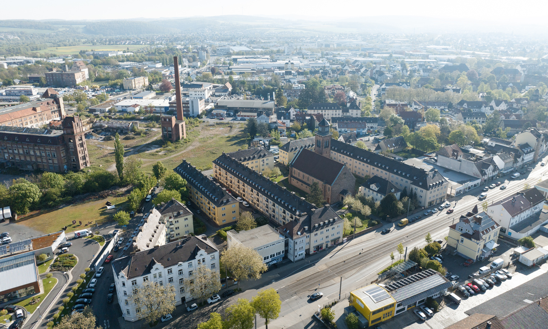 Luftaufnahme mit der Kirche St. Kunigundis in Kassel-Bettenhausenn. Im Hintergrund ist das Areal der Salzmannfabrik zu sehen.