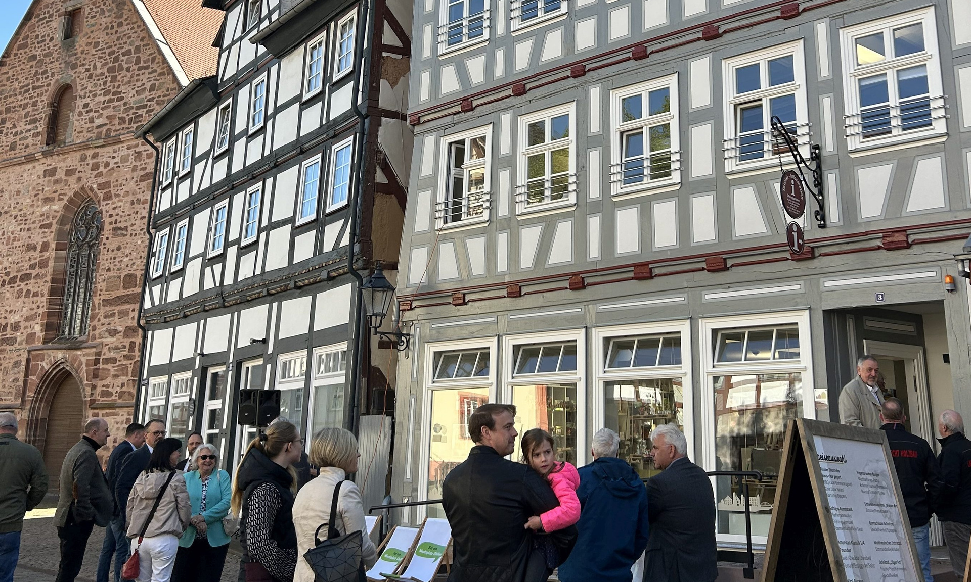 Mehrere Menschen vor einer schönen restaurierten Fachwerkkulisse in Rotenburg an der Fulda