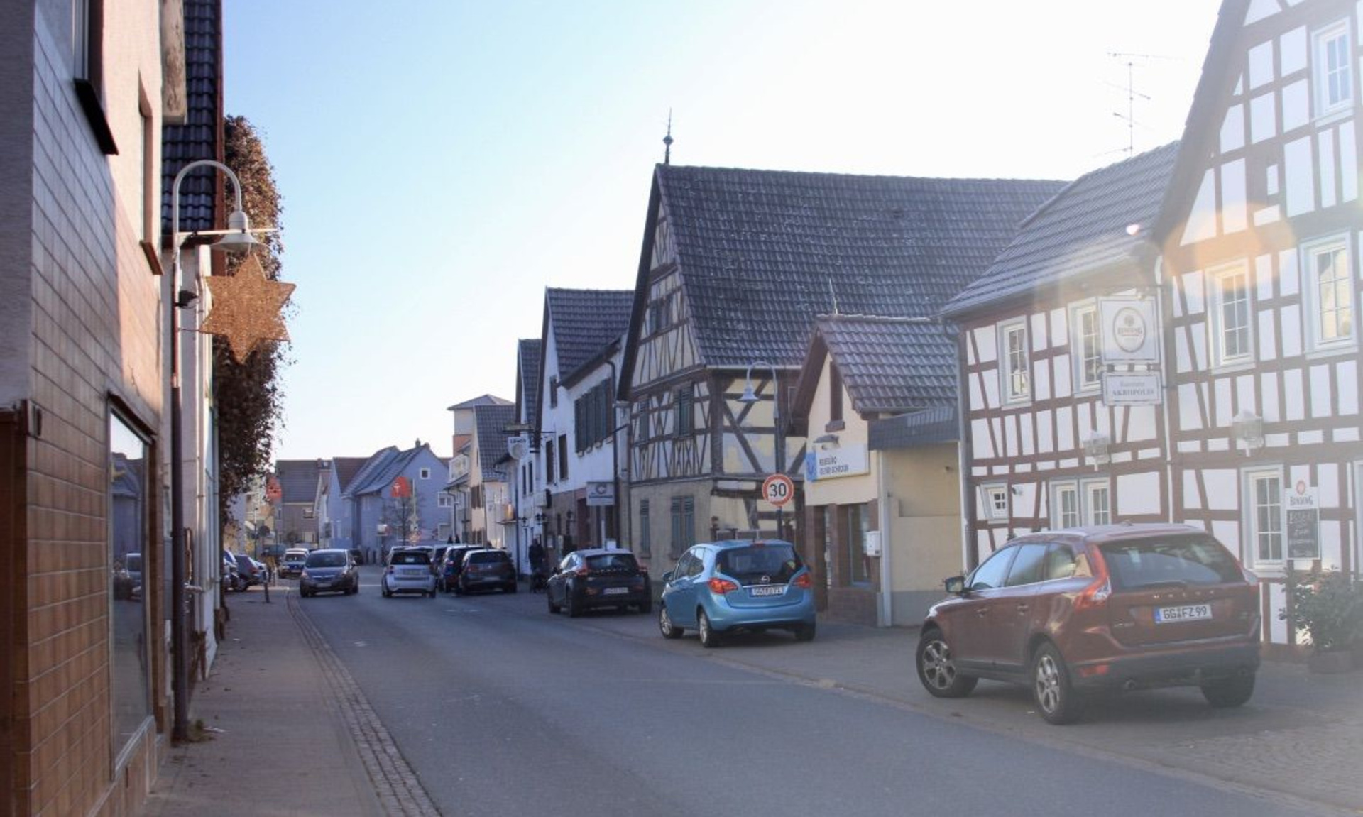 Autos in einer Straße mit Fachwerkhäusern