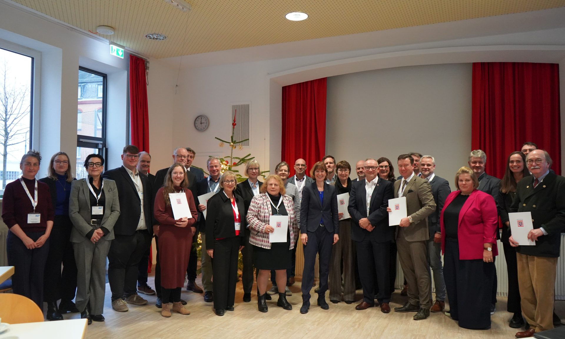 Vertreter der Kommunen, die neu ins Städtebauförderprogramm Sozialer Zusammenhalt aufgenommen wurden, mit ihren Urkunden beim gemeinsamen Fototermin.