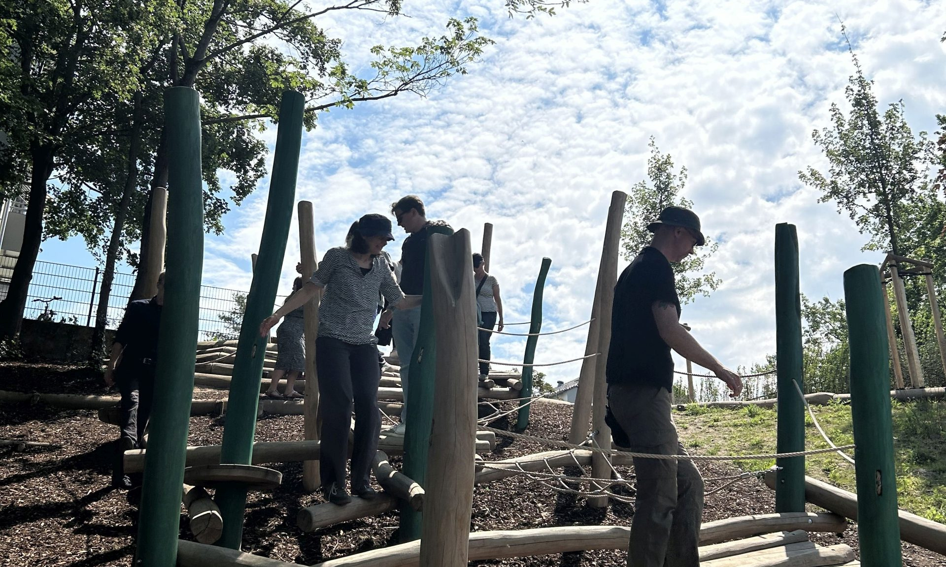 Erwachsene balancieren über eine Station des neuen Abenteuerspielplatzes in Kelsterbach
