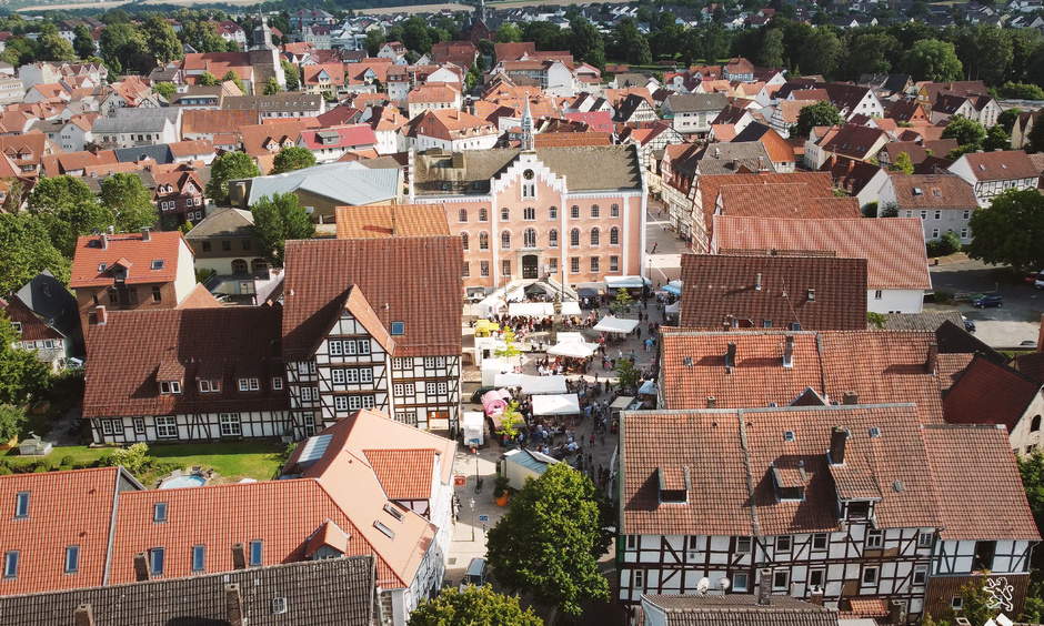 Blick von oben auf das durch einen Markt belebte Stadtzentrum von Hofgeismar, viele Fachwerkhäuser