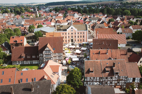 Blick von oben auf das durch einen Markt belebte Stadtzentrum von Hofgeismar, viele Fachwerkhäuser