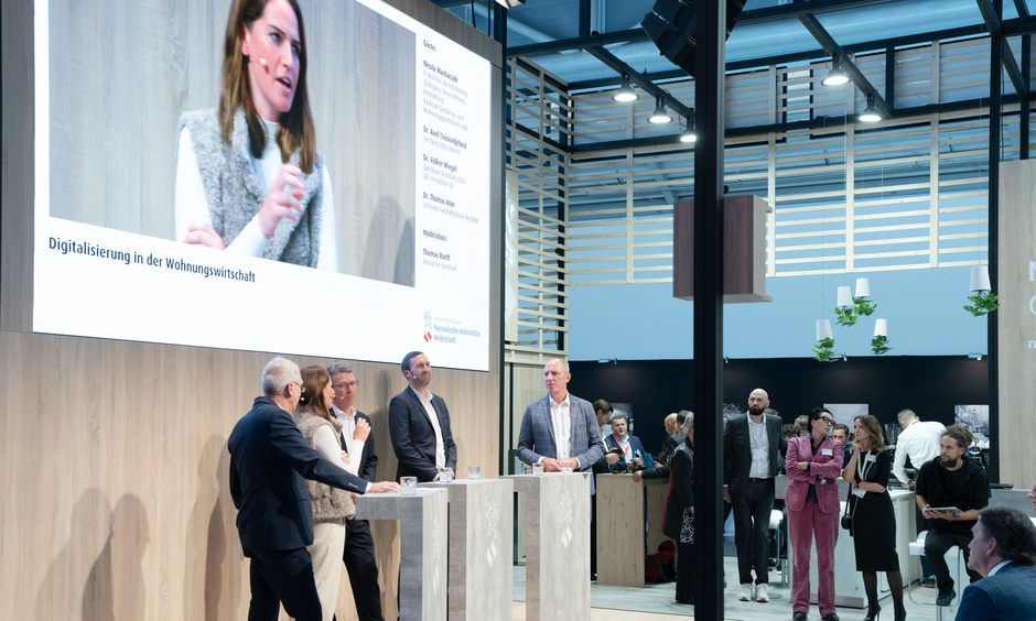 Teilnehmer der Podiumsdiskussion "Digitalisierung in der Wohnungswirtschaft" am NHW-Stand mit Moderator Thomas Ranft