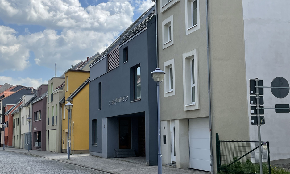 Eine Reihe modernisierter Häuser an einer Pflasterstraße.